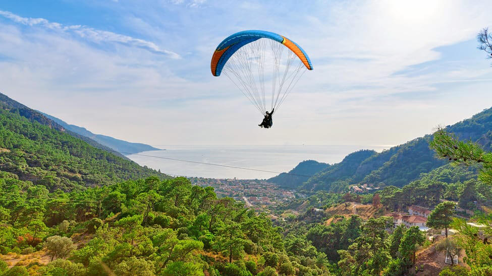 Parapente con fondo de montañas al atardecer